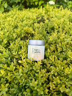 Small cylindrical container labeled 'Dear Nature' hidden among green leaves